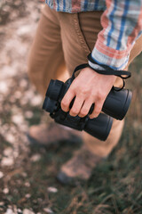 Wall Mural - Woman is standing with binoculars in her hand. Top-down view. Selective focus on binoculars.