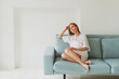 © Natalya - portrait of a young charming woman in a silk robe at home on the sofa