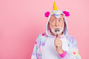 Sticker - Portrait of attractive comic hungry sad grey-haired man licking spoon eating meal copy space isolated over pink color background