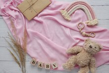Pregnancy Announcement Background, Expecting A Baby Girl Concept, Flat Lay Composition On Pink Blanket With Boho Rainbow Decoration And Soft Toy Bear.