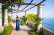 A young blonde girl walking in the patio of an historic villa in Capri island. Capri, Italy.
