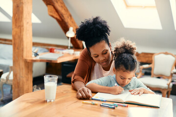 Wall Mural - Happy African American mother enjoys in creative time with her daughter at home.