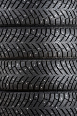 Wall Mural - New winter car tires with spikes close-up vertically. Texture, background