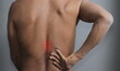 © herlanzer - back pain discomfort after pulling a muscle with grey background stock photo
