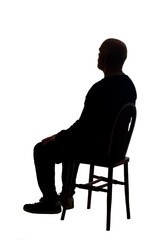 rear view of the silhouette of a man sitting on chair with casual clothes looking away