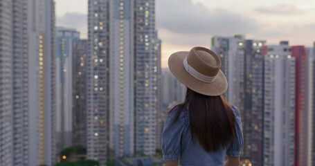 Poster - Woman look at the city at sunset