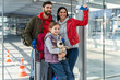 © NFstock - Happy family in airport departures. People in terminal preparing for the vacation while looking at the distance with happy faces