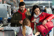 © NFstock - Happy family of three preparing undergoing check-in procedures at the airport. Mother, father and daughter preparing to the traveling