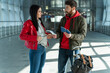© NFstock - Young man and woman arguing with each other while holding tickets and standing at the airport. Problems concept