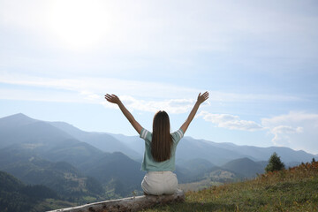 Canvas Print - Young woman in peaceful mountains, back view. Feeling freedom