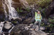 © New Africa - Tourist with backpack near waterfall in mountains. Space for text