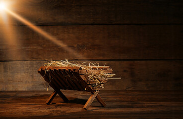 Wall Mural - Manger with hay on wooden background. Concept of Christmas story