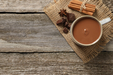 Flat lay composition with yummy hot chocolate on wooden table. Space for text