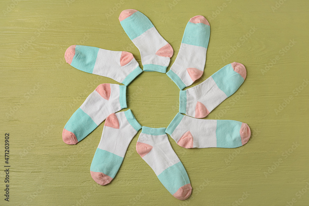 Frame made of socks on color wooden background