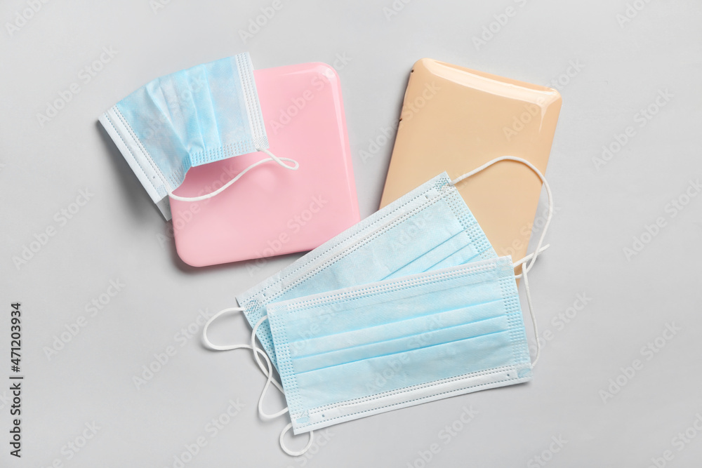 Medical masks with cases on light background