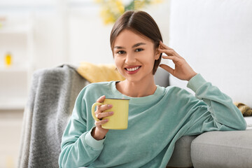 Wall Mural - Beautiful young woman drinking tasty tea on at home