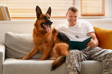 Soldier of USA army with military working dog reading book at home