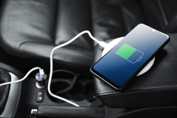 Mobile phone ,smartphone, cellphone is charged ,charge battery with usb charger in the inside of car. modern black car interior