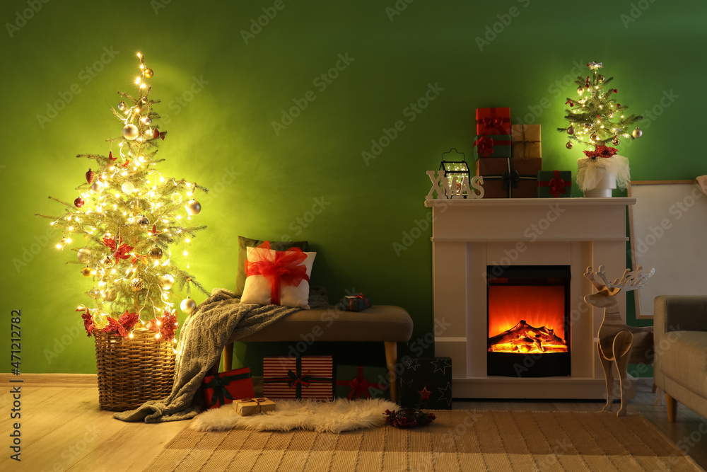 Interior of dark living room with fireplace, Christmas trees and glowing lights