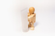 © Ilya - Wooden man and empty plastic tube in hands.