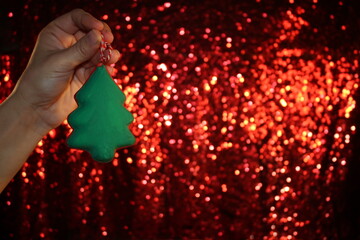 Wall Mural - beautiful green Christmas tree is lying on your hand on a shiny background