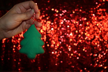 Wall Mural - beautiful green Christmas tree is lying on your hand on a shiny background