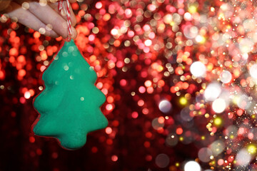 Wall Mural - beautiful green Christmas tree is lying on your hand on a shiny background