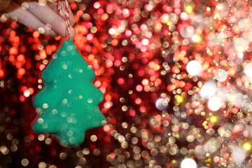 Wall Mural - beautiful green Christmas tree is lying on your hand on a shiny background