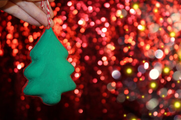 Wall Mural - beautiful green Christmas tree is lying on your hand on a shiny background