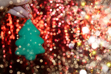 Wall Mural - beautiful green Christmas tree is lying on your hand on a shiny background