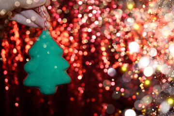 Wall Mural - beautiful green Christmas tree is lying on your hand on a shiny background