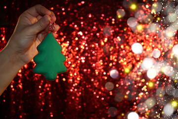 Wall Mural - beautiful green Christmas tree is lying on your hand on a shiny background