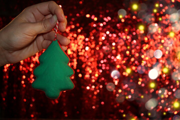 Wall Mural - beautiful green Christmas tree is lying on your hand on a shiny background