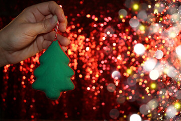 Wall Mural - beautiful green Christmas tree is lying on your hand on a shiny background