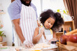 © chayantorn - Happy African American father and daughter having fun while preparing cookie dough at home. happy family time.