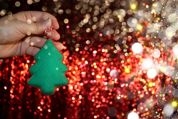 Wall Mural - beautiful green Christmas tree is lying on your hand on a shiny background