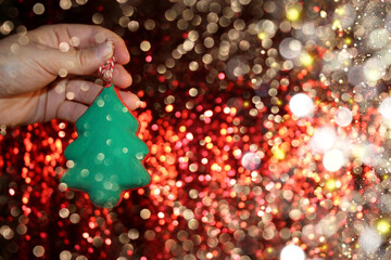 Wall Mural - beautiful green Christmas tree is lying on your hand on a shiny background