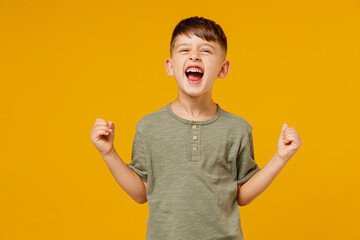 full body little small fun happy boy 6-7 years old wearing green t-shirt sit in bag chair do winner 