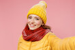 © ViDi Studio - Close up fascinating charismatic stunning young woman 20s years old wear yellow jacket hat mittens doing selfie shot pov on mobile phone isolated on plain pastel light pink background studio portrait