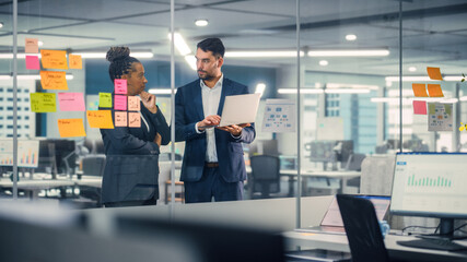 Aufkleber - Young Businessman Talking with Experienced Colleague while Using Laptop Computer in Office. Employees Discuss Corporate, Financial and Marketing Projects. Specialists Work in Diverse Team.