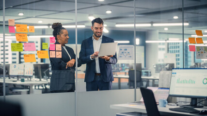 Aufkleber - Young Businessman Talking with Experienced Colleague while Using Laptop Computer in Office. Employees Discuss Corporate, Financial and Marketing Projects. Specialists Work in Diverse Team.