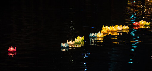 Wall Mural - Floating colored lanterns and garlands on river at night on Vesak day in Saigon River for celebrating Buddha's birthday, that made from paper and candle. Asian culture.