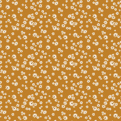 Beautiful floral pattern in small abstract chamomile flowers. Small white flowers. Mustard background. Ditsy print. Floral seamless background. The elegant the template for fashion prints. Stock.
