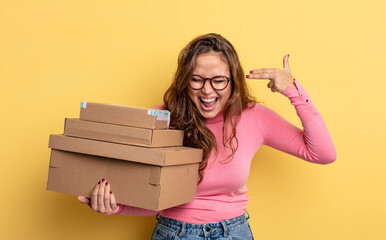 Wall Mural - hispanic pretty woman looking unhappy and stressed, suicide gesture making gun sign. storage concept