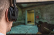 © yaroslav1986 - Close-up rear view of a young man with headphones playing an action video game on a computer at home