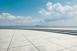 Fototapeta  - Empty square floor and river with mountains under blue sky