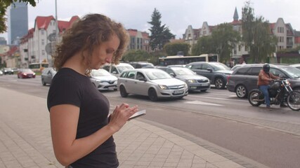 Poster - Using a mobile phone in the city. A woman is looking for a free car for a trip. The movement of cars on the road. focus on the screen. Being late for work.