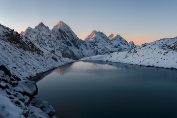 Poster - A high-mountain lake against a background of snow-covered mountain peaks in the early morning in the Karachay-Cherkessia Republic