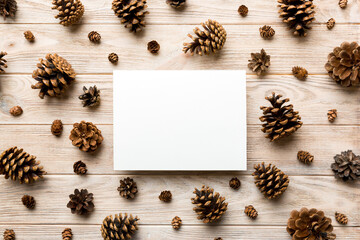 Wall Mural - Creative frame made of Christmas pine cones with square Paper blank. Xmas and New Year theme. Flat lay, top view copy space