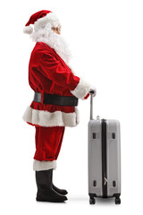 Wall Mural - Full length profile shot of santa claus standing with a suitcase